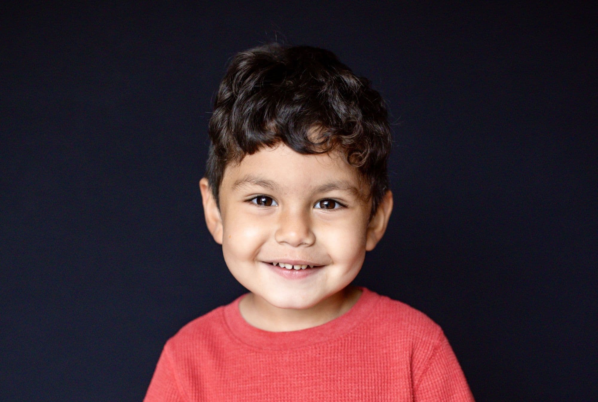 San Francisco elementary school portrait of smiling boy in navy vest over white collared shirt