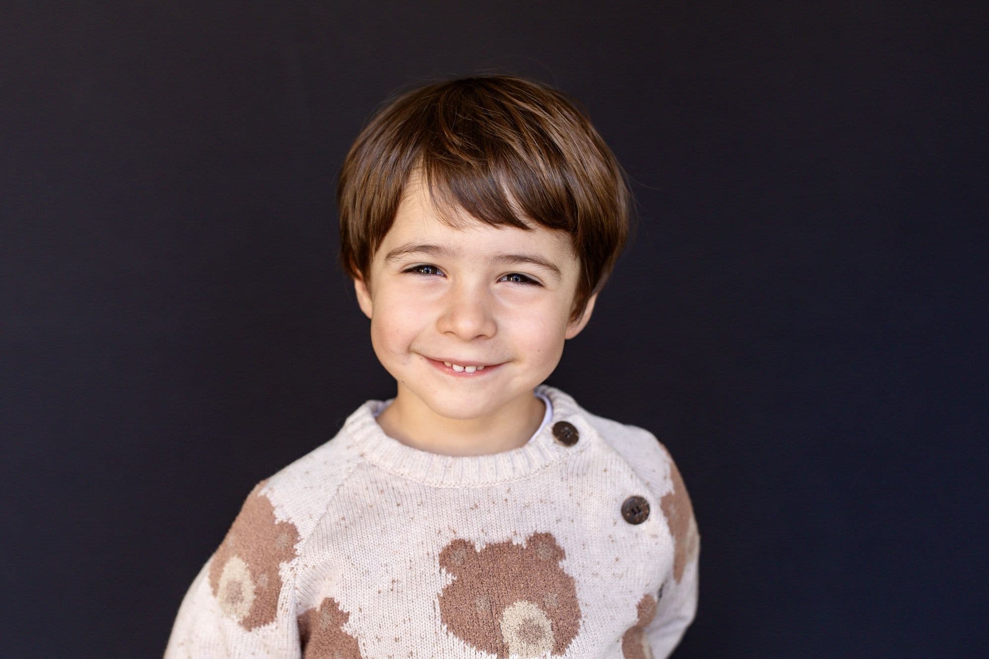 Professional San Francisco school photo of smiling student wearing cream bear pattern sweater