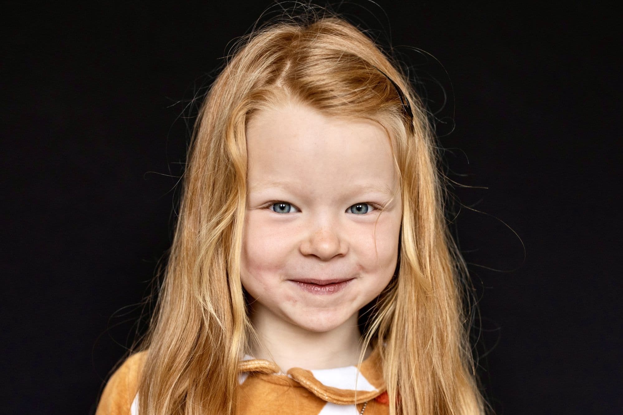 Professional school photo by San Francisco photographer of blonde girl in orange button-up cardigan