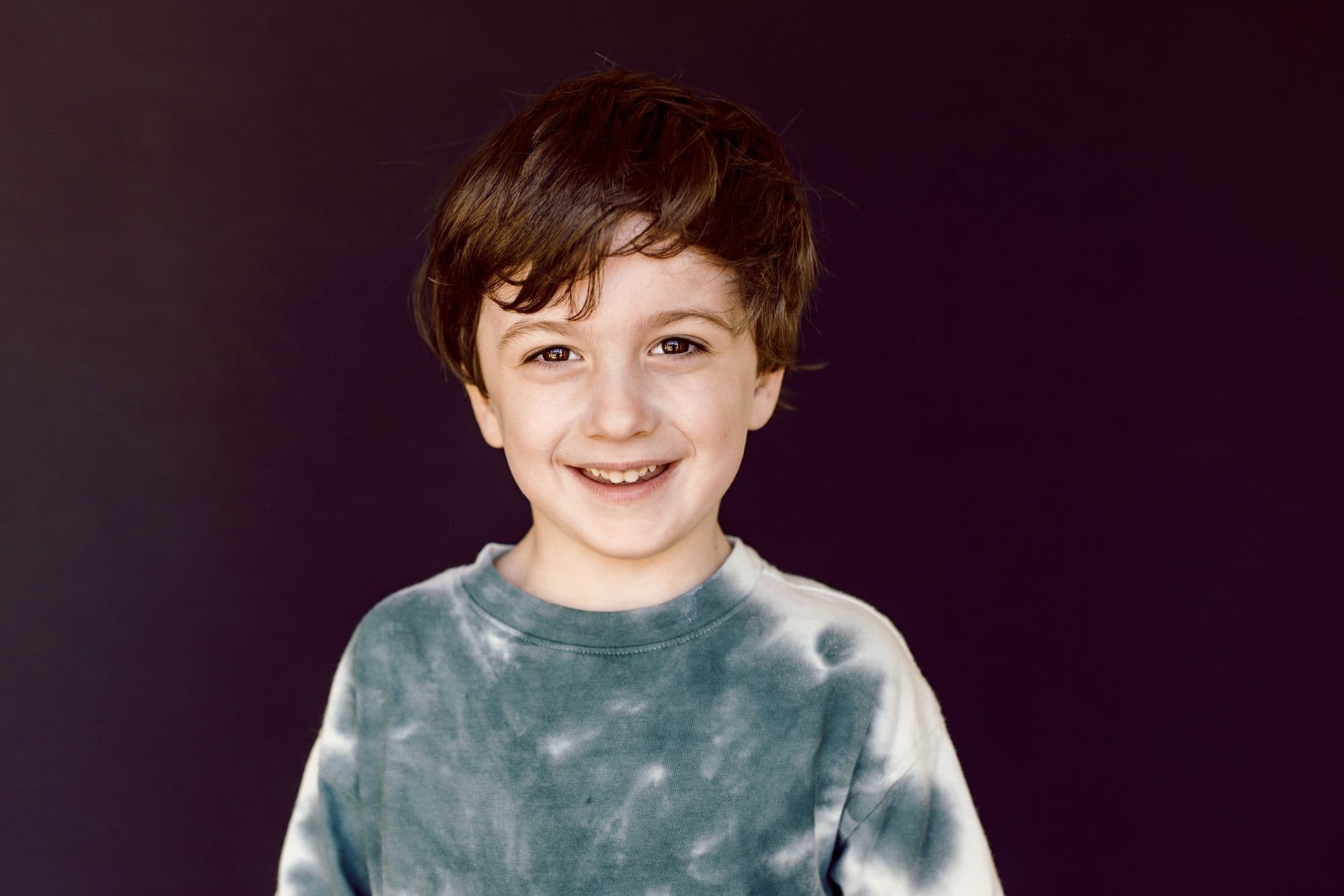 San Francisco elementary school portrait of boy with wavy hair in blue and white tie-dye shirt