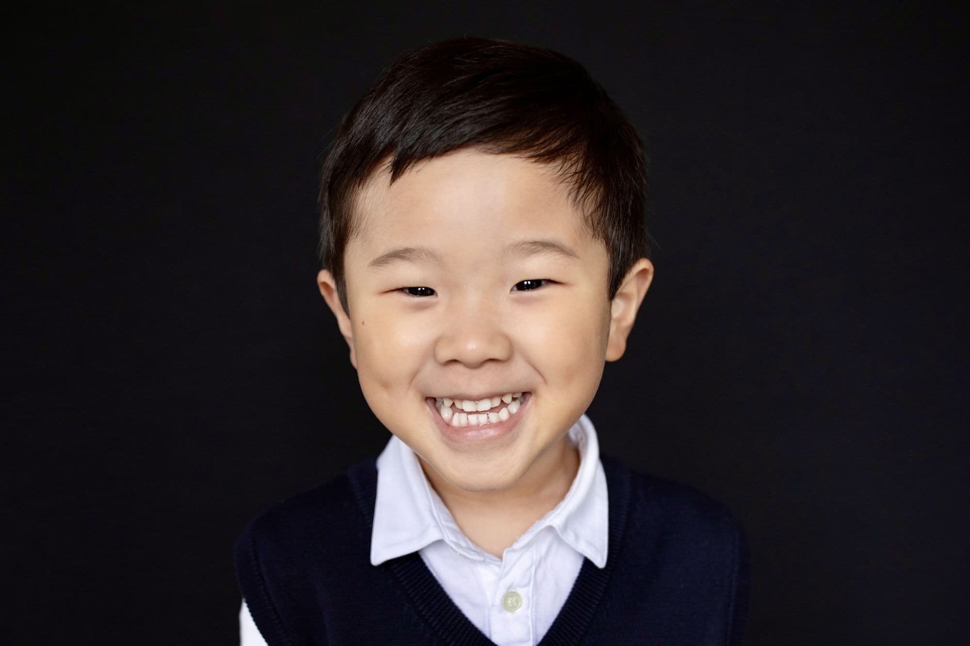 San Francisco school photo of student with curly dark hair wearing bright red knit sweater