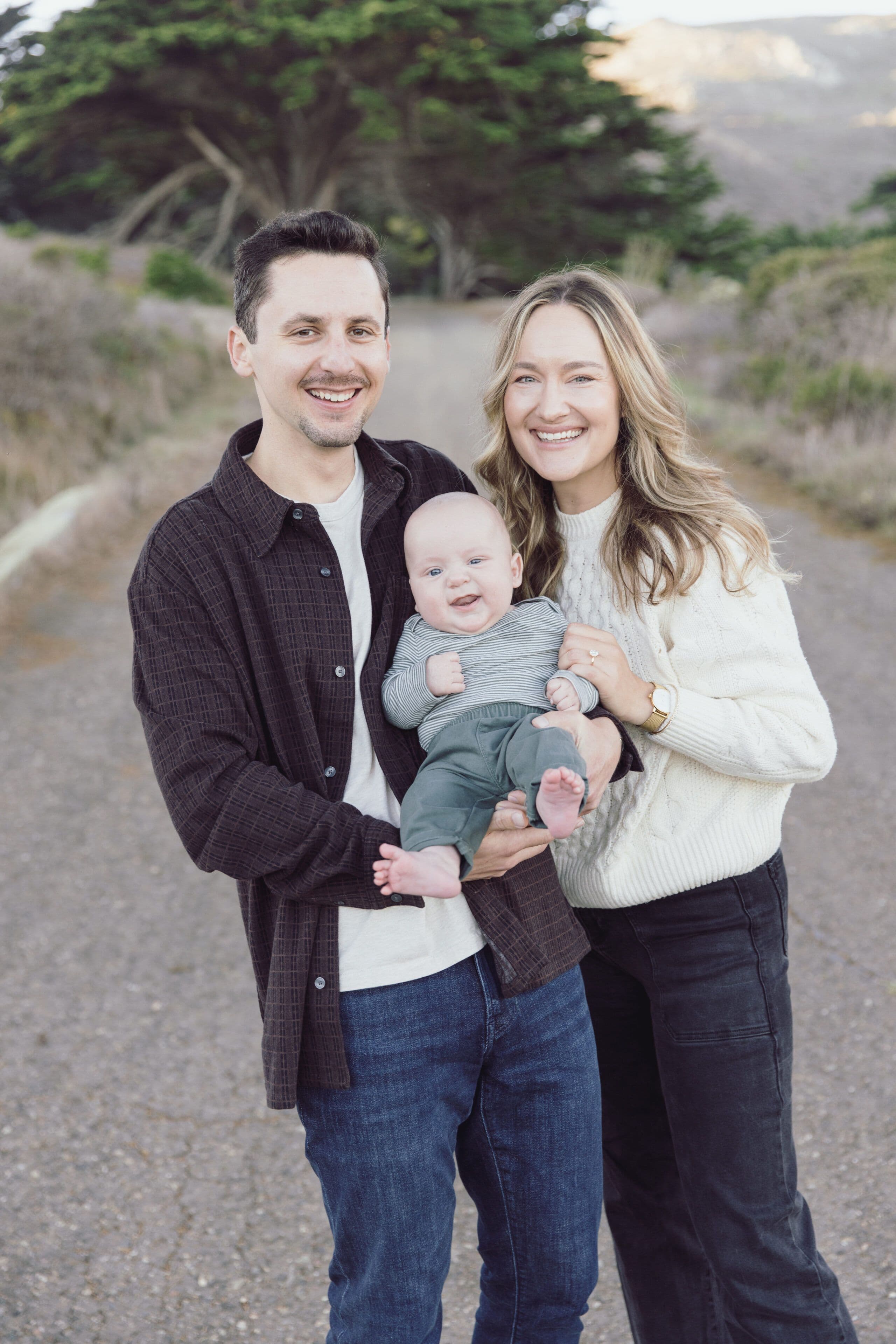 Family of three walking along a trail above Rodeo Beach in the Marin Headlands