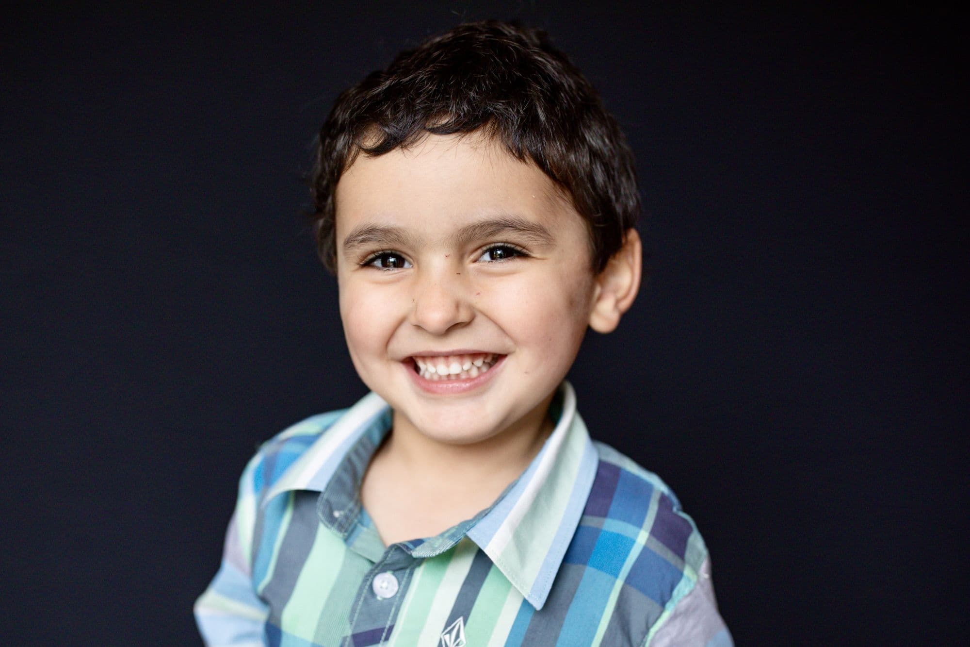 Professional school photo by San Francisco photographer of boy with dark hair in gray sweater