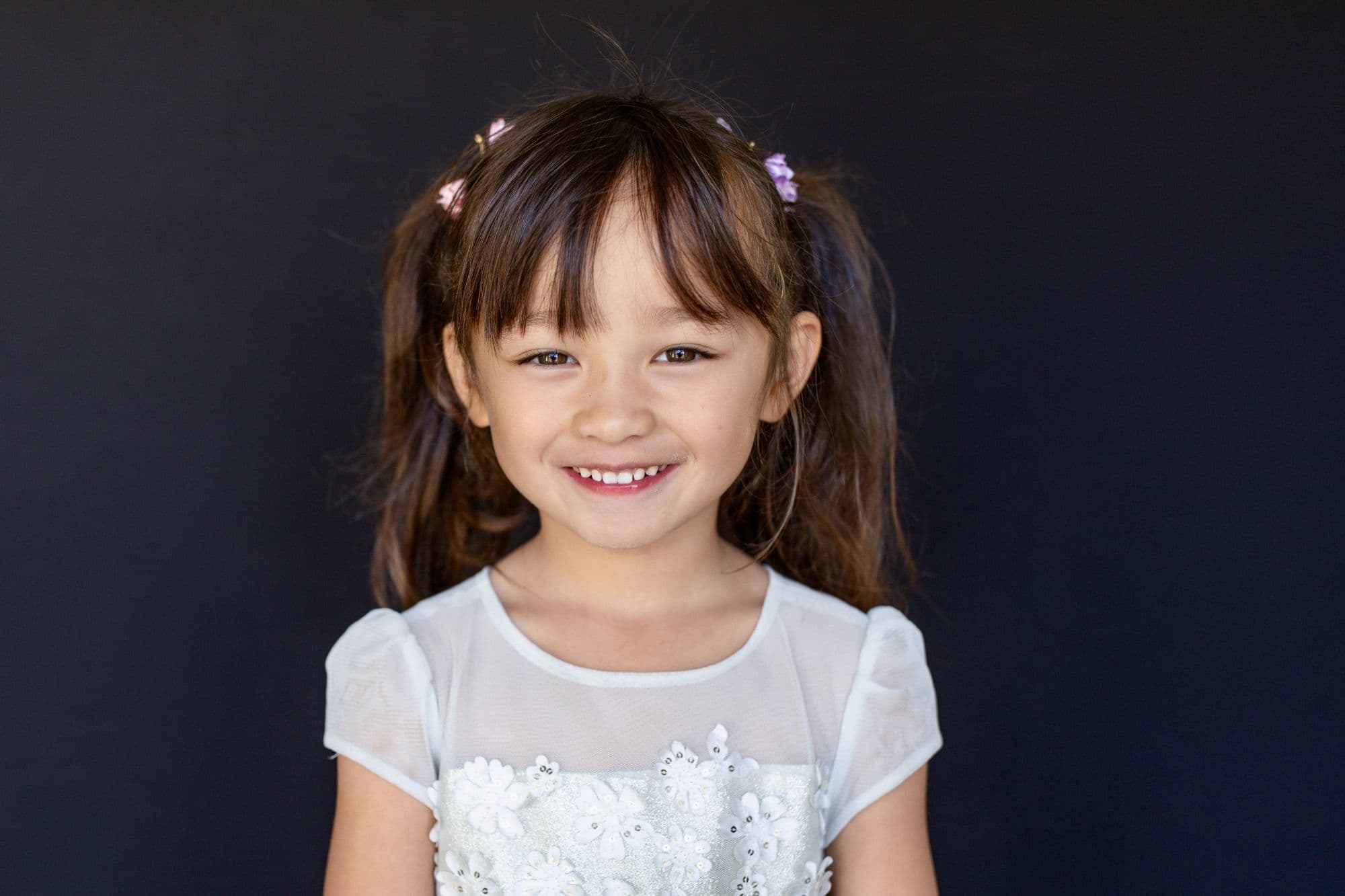Professional school photo by San Francisco photographer of blonde girl with navy headband and flower